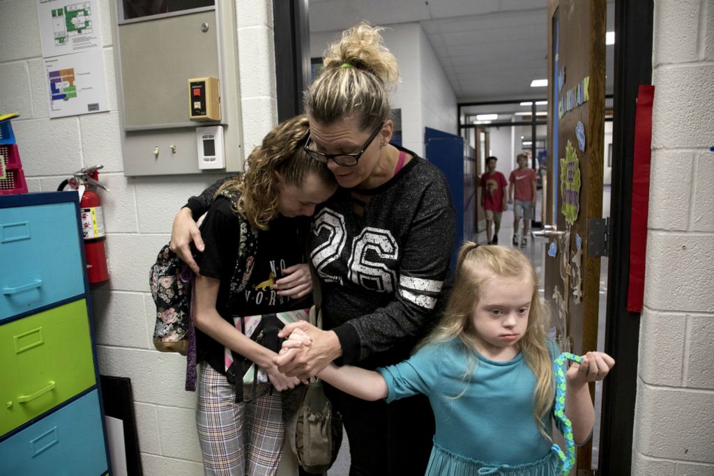 First Place, Feature Picture Story - Jessica Phelps / Newark Advocate, “Living on Love”Leah Hrebluk is a single mom raising two daughters with special needs.  Her children are the reasons why Leah continues to advocate, and the reason why she views life through a different lens. A positive one. “We're still living the life. We may not be able to do as much as some people do,” Leah said. “But we take what we can. We do it. And then when enough is enough, we go back home and we rest.” Leah Hrebluk holds onto her daughter, Sophia, and coaxes her into her new classroom on the first day of school in Granville August 21, 2019. Sophia was nervous about starting 7th grade in a new school away from the teachers and friends she had made while at Licking Valley.